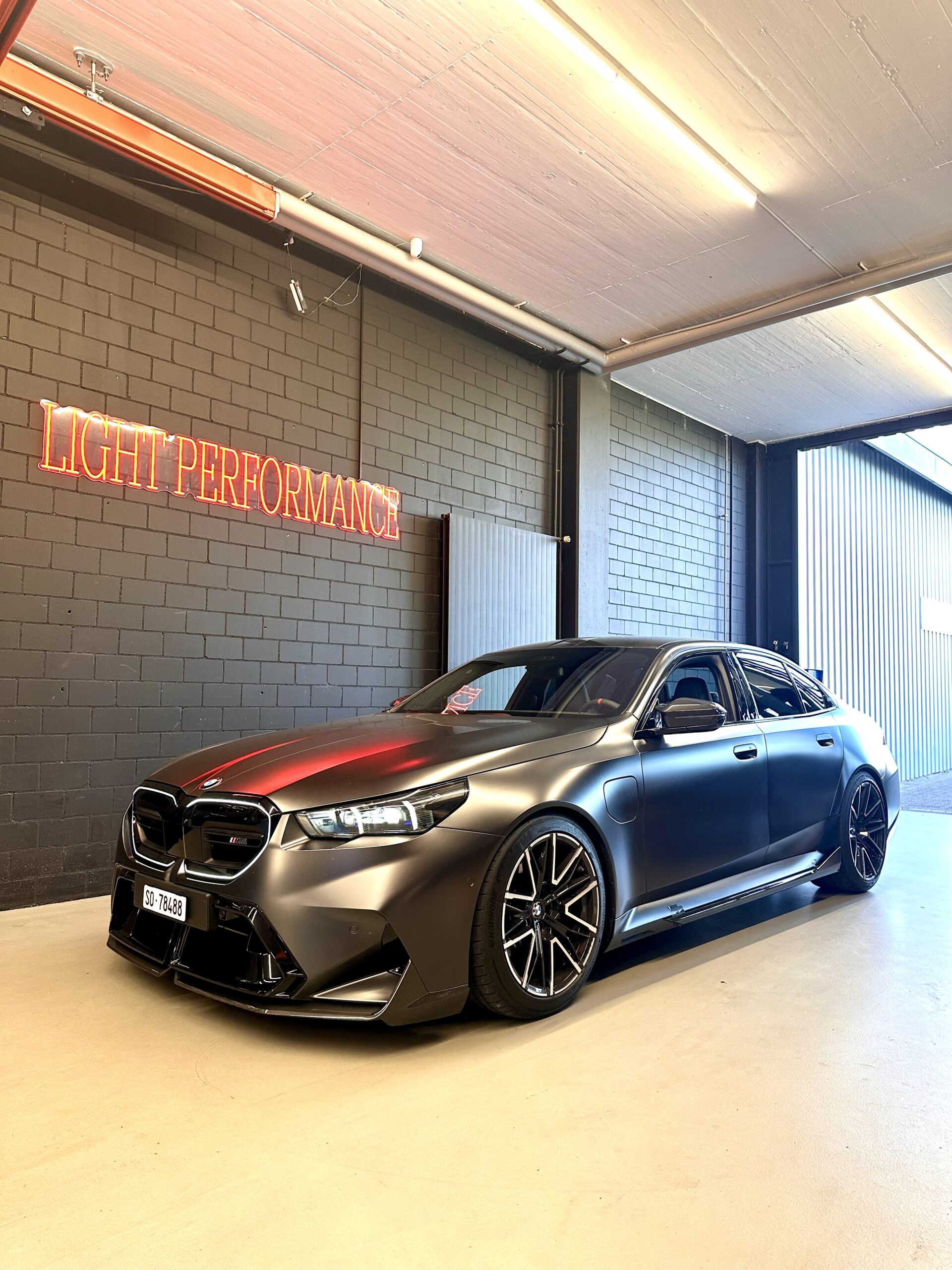 Sportliches Auto in Garage mit Neonschriftzug