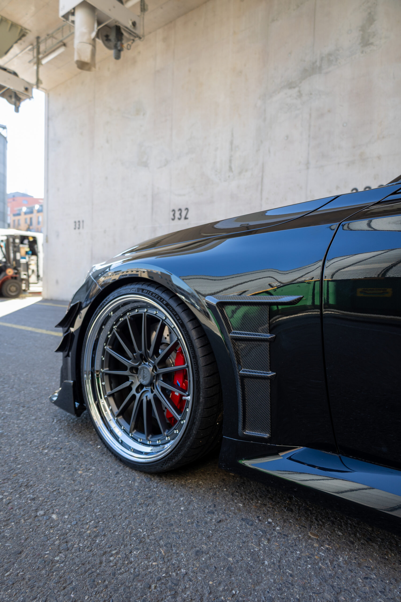 Sportwagenreifen mit roten Bremssätteln auf Asphalt