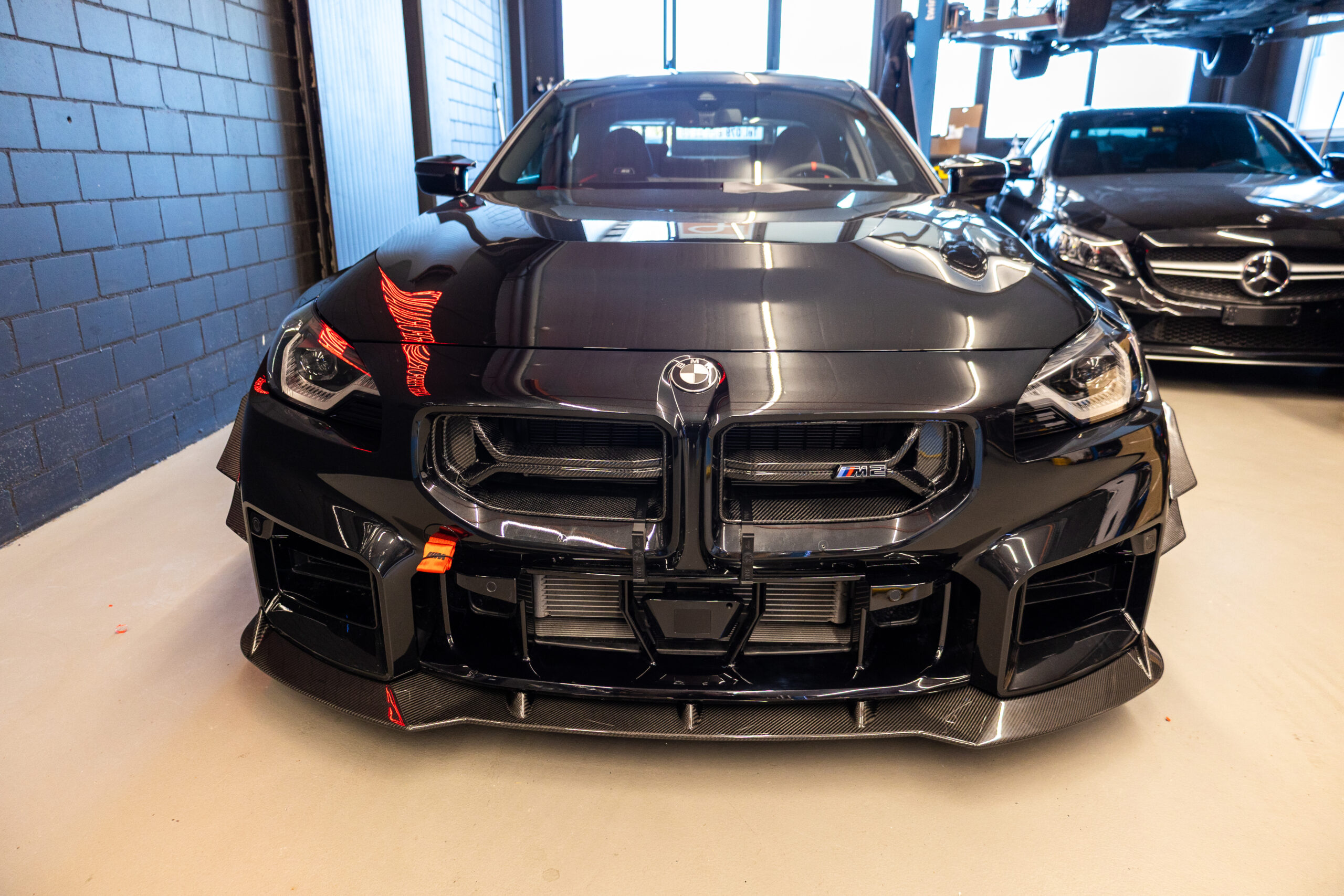 Schwarzes Auto in einer Garage von vorne.