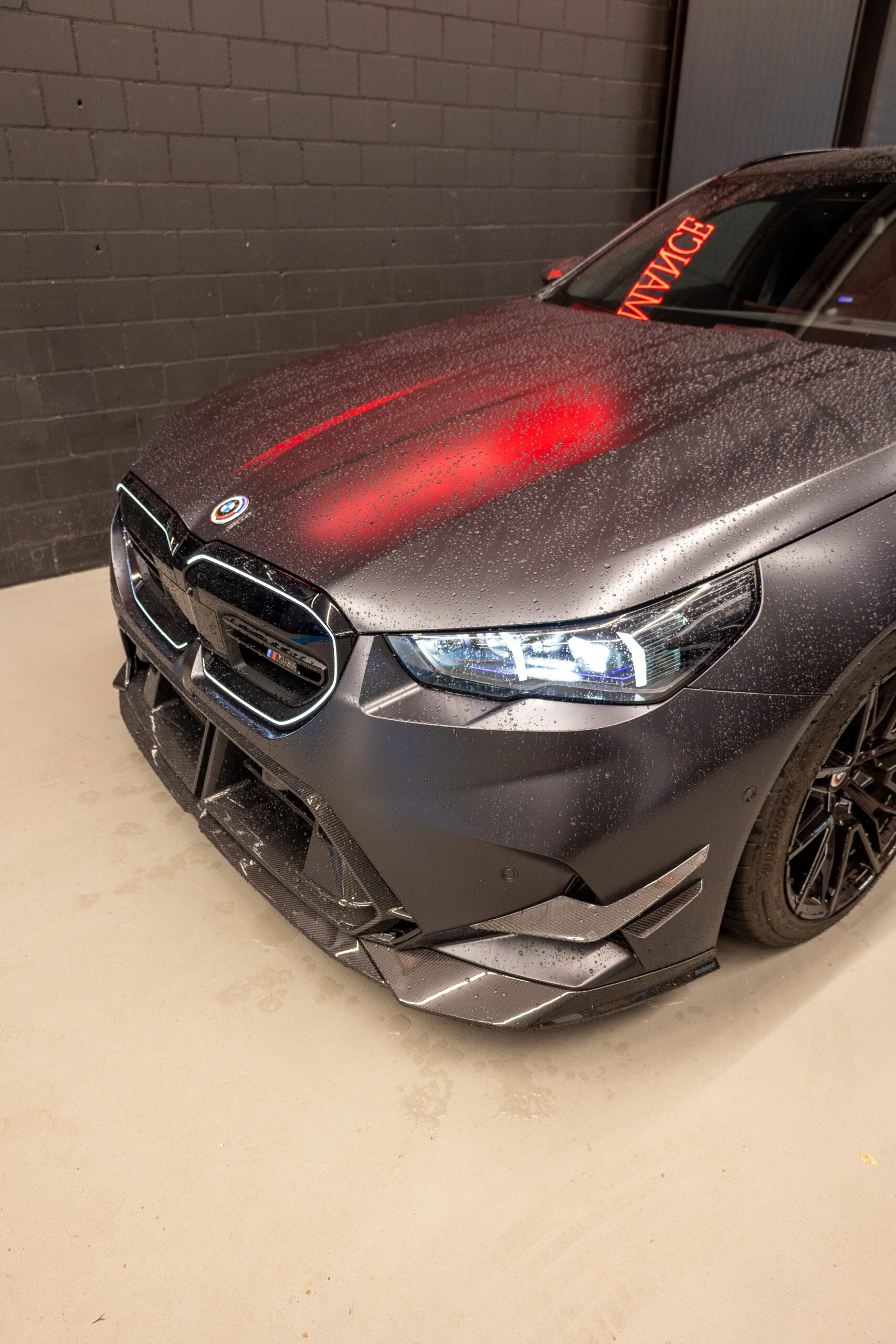 Mattgraues Auto mit roten Lichtern und Regentropfen