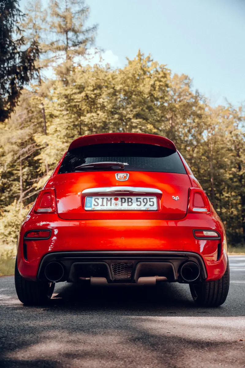 Rotes Auto von hinten auf Landstraße.