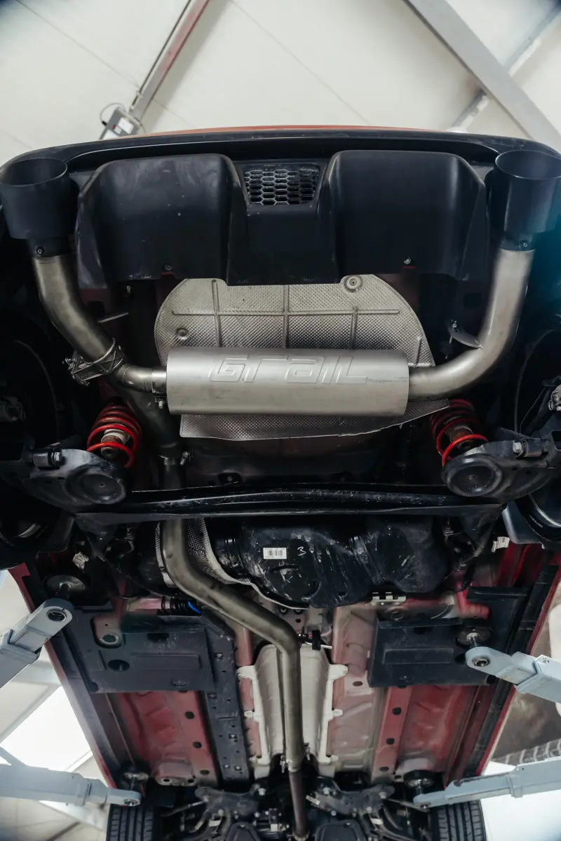 Unterseite eines Autos mit Auspuffsystem.