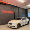 Weißes Auto in Garage mit Neonlicht