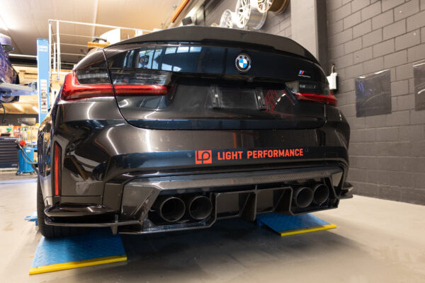 Hinteransicht eines BMWs in einer Werkstatt.